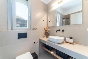 a bathroom with a sink and a mirror at Ayelma - Kythnos Villa in Kithnos