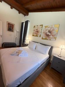 ein Schlafzimmer mit einem weißen Bett und zwei Bildern an der Wand in der Unterkunft Sottocastello 2 in Gorizia