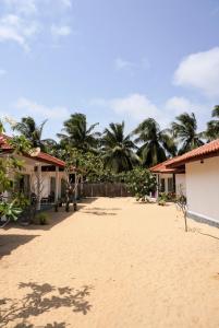 a sandy beach with houses and palm trees at Summer wave kudawa and Kite surfing school in Kalpitiya