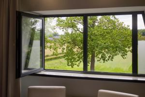 a window with a view of a tree at Van der Valk Hotel de Bilt-Utrecht in De Bilt
