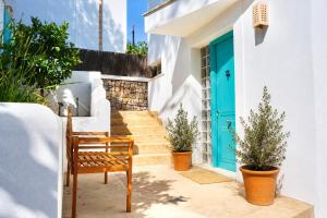 a wooden bench sitting in front of a house with a blue door at Villa Riviera in Cala d´Or