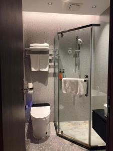 a bathroom with a glass shower with a toilet at Merica Hotel-ChongQing jiefangbei in Chongqing +35 photos