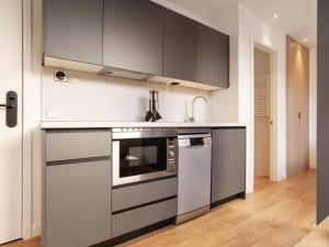 a kitchen with black and white appliances and wooden floors at Catalina Retiro Madrid in Madrid +35 photos