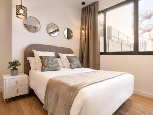 a bedroom with a large white bed and a window at Catalina Retiro Madrid in Madrid