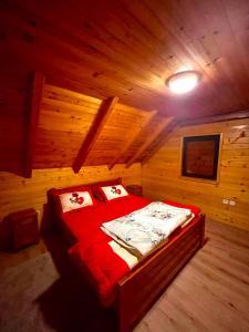 a bedroom with a bed in a wooden cabin at Vikendica Veruša in Veruša +4 photos