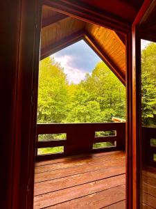 an open door to a deck with a view of trees at Vikendica Veruša in Veruša