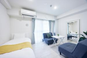 a bedroom with a bed and a couch and a chair at Montana Flat Yebisu in Osaka