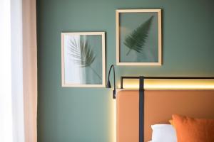 two framed pictures on a wall above a bed at Best Western Plus Hôtel de Robien in Saint-Brieuc +147 photos
