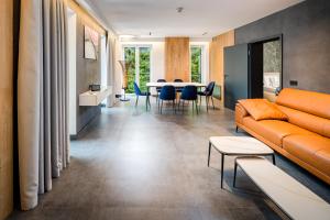 a living room with a couch and a table at DAS ERZ Medical Spa & Hotel in Crottendorf