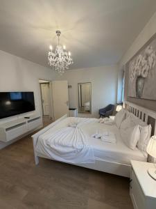 a bedroom with a large white bed and a chandelier at Sottocastello 1 in Gorizia