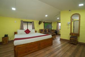a bedroom with a bed and a chair and a mirror at Padmabati Park in Balasore +32 photos
