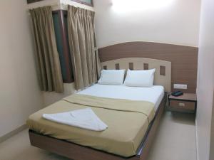 Кровать или кровати в номере Banyan Tree Comforts Mysore