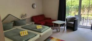 a bedroom with two beds and a couch and a chair at WAGNERS Hotel im Bayerischen Wald in Grafenau