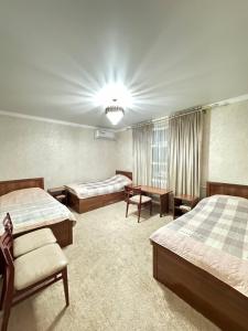 a bedroom with two beds and a chandelier at NUKUS GUEST HOUSE in Nukus