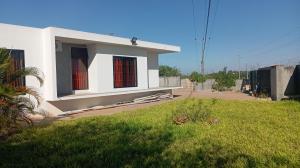 a white house with red windows and a yard at Pati place in Mememo +6 photos