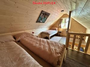 a bedroom with a bed in a wooden cabin at MK Apartment Karpaty in Zvončín +136 photos