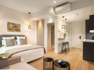 a bedroom with a large bed and a kitchen at Catalina Retiro Madrid in Madrid
