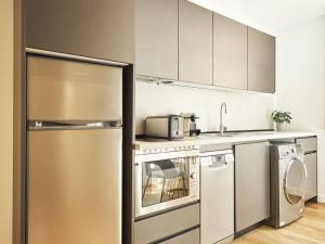 a kitchen with stainless steel appliances and white cabinets at Catalina Retiro Madrid in Madrid