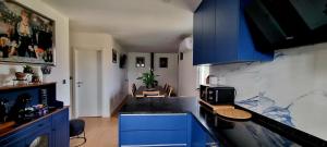 a kitchen with blue cabinets and a black counter top at Caia House in Ourondo