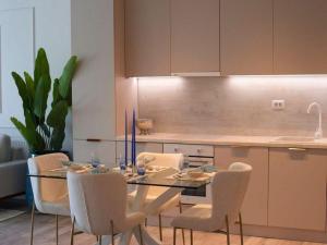 a kitchen with a glass table and chairs in a kitchen at Apartament Marreo Casa del Mar in Mamaia