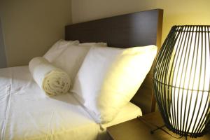 a bed with white pillows and a brown head board at DW Motel in Koror