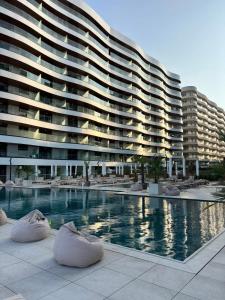 a large building with a swimming pool in front of it at Apartament Marreo Casa del Mar in Mamaia