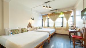 two beds in a room with two windows at Retro At Phra Sing Guest House in Chiang Mai +287 photos