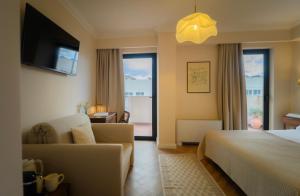 a hotel room with a bed and a couch at Hotel Maroussi in Athens +34 photos
