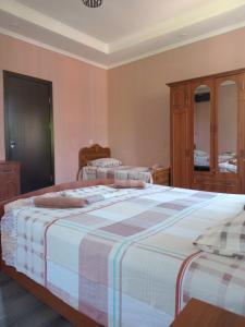 two beds in a bedroom with pink walls at Guest house Gio in Kobuleti