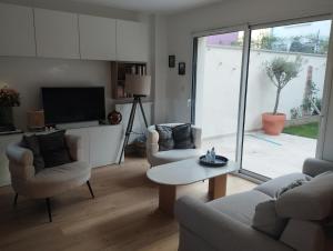 a living room with two chairs and a table and a tv at House in Clamart