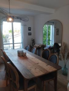 a dining room with a wooden table and chairs at House in Clamart +2 photos