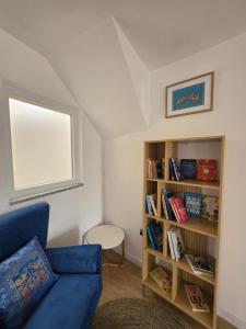 a living room with a blue couch and a book shelf at Caia House in Ourondo