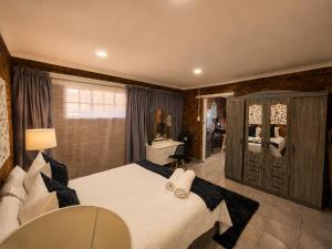 a bedroom with a large white bed and a dresser at Zhantique Guest House 1- Unit 3 in Boksburg
