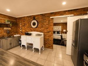 a kitchen with brick walls and a kitchen with a refrigerator at Zhantique Guest House 1- Unit 3 in Boksburg