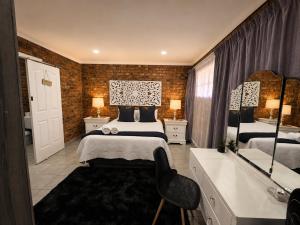a bedroom with two beds and a bathroom with a tub at Zhantique Guest House 1- Unit 3 in Boksburg