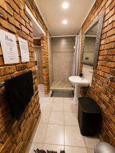 a bathroom with a sink and a brick wall at Zhantique Guest House 1- Unit 3 in Boksburg +6 photos