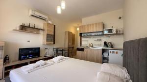 a bedroom with a white bed and a kitchen at Bratanov Cascadas Ravda in Ravda