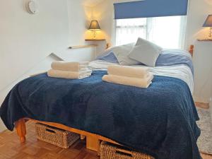 a bedroom with a bed with towels on it at Mole Cottage - Uk52139 in Liskeard