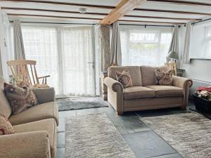 a living room with two chairs and a couch at Mole Cottage - Uk52139 in Liskeard