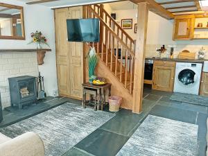 a living room with a staircase and a tv at Mole Cottage - Uk52139 in Liskeard