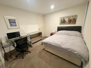 a bedroom with a bed and a desk with a computer at Spacious Master Room with Private Ensuite in Melbourne