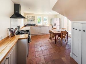 a kitchen with a table and a kitchen with white cabinets at The Cottage in Chelsworth