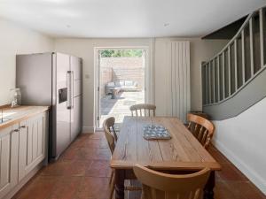 a kitchen with a wooden table and a refrigerator at The Cottage in Chelsworth