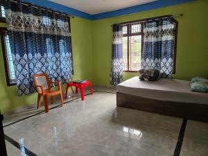 a room with two beds and a chair and windows at Sharma Residency in Dithur