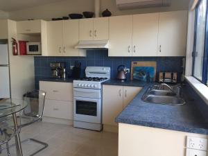 a kitchen with a sink and a stove top oven at Rumah Pantai in Emu Bay