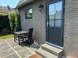 een tafel en een stoel voor een deur bij Luxe Tiny House Ooij in Ooij +1 foto