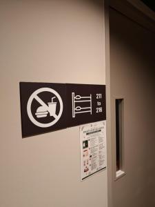 a sign on the wall of a bathroom with a no smoking sign at Straits Heritage Hostel in Singapore
