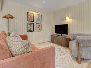 a living room with a couch and a television at Meadow Barn in Pulborough