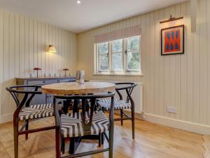 a kitchen with a table and chairs in a room at Meadow Barn in Pulborough