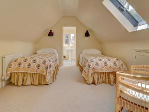 a attic bedroom with two beds and a window at Meadow Barn in Pulborough +8 photos